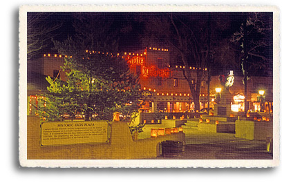 Looking across Taos Plaza to the Hotel La Fonda de Taos, decorated with luminarias for Christmas 